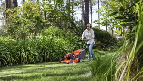 En tjej som klipper gräsmattan med en Husqvarna gräsklippare